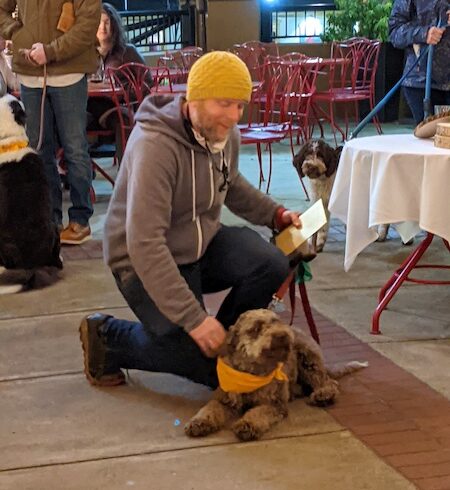 Johnathan Taylor congratulates Mia, a 17-month-old Lagotto Romagnola, for finding the most truffles during the 2022 Oregon Trufffle Festival Joriad competition.